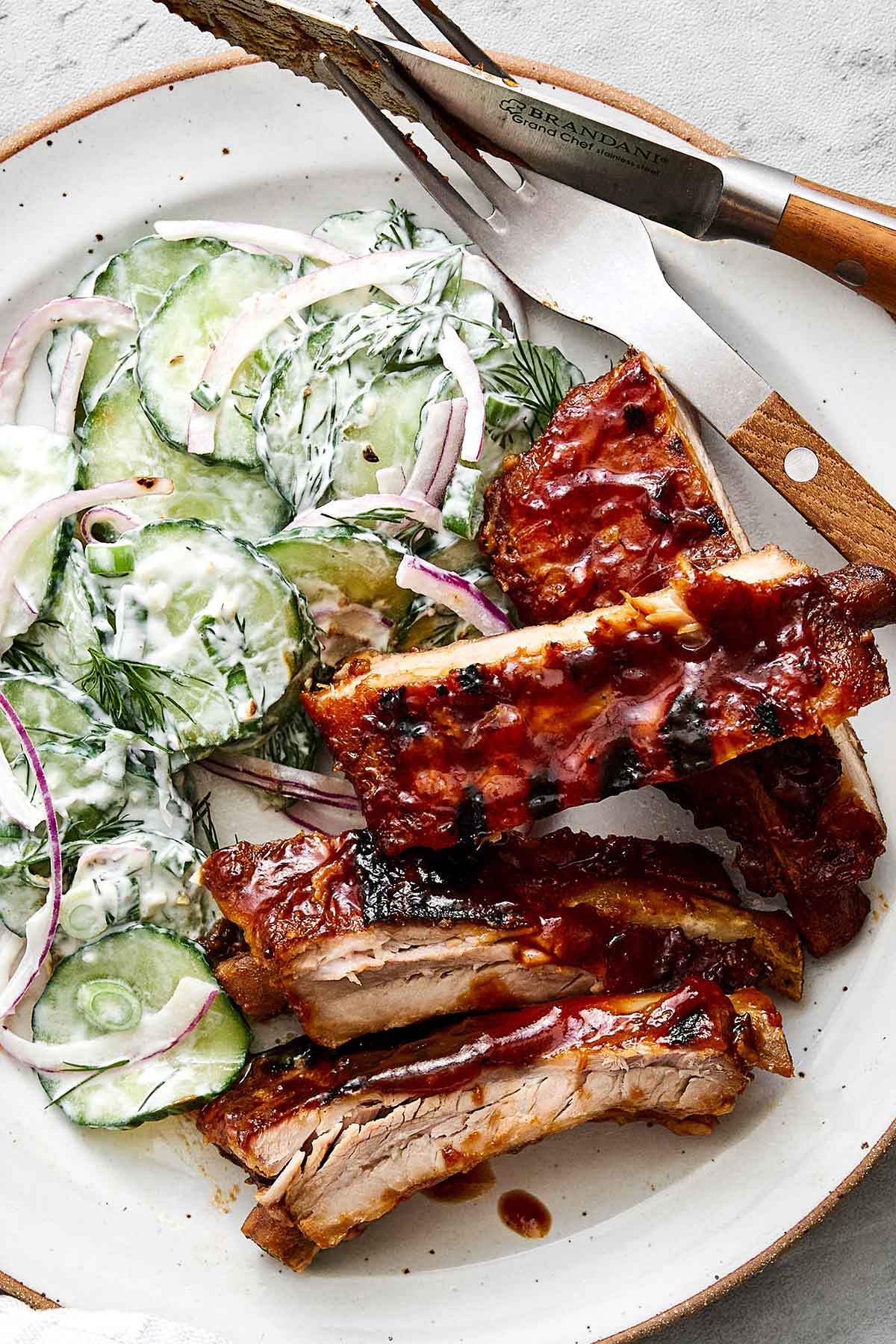 These baby back ribs are my secret to the best cookout meal. Guaranteed to be fall-apart tender with the best pineapple BBQ sauce! Baby back ribs with creamy cucumber salad.