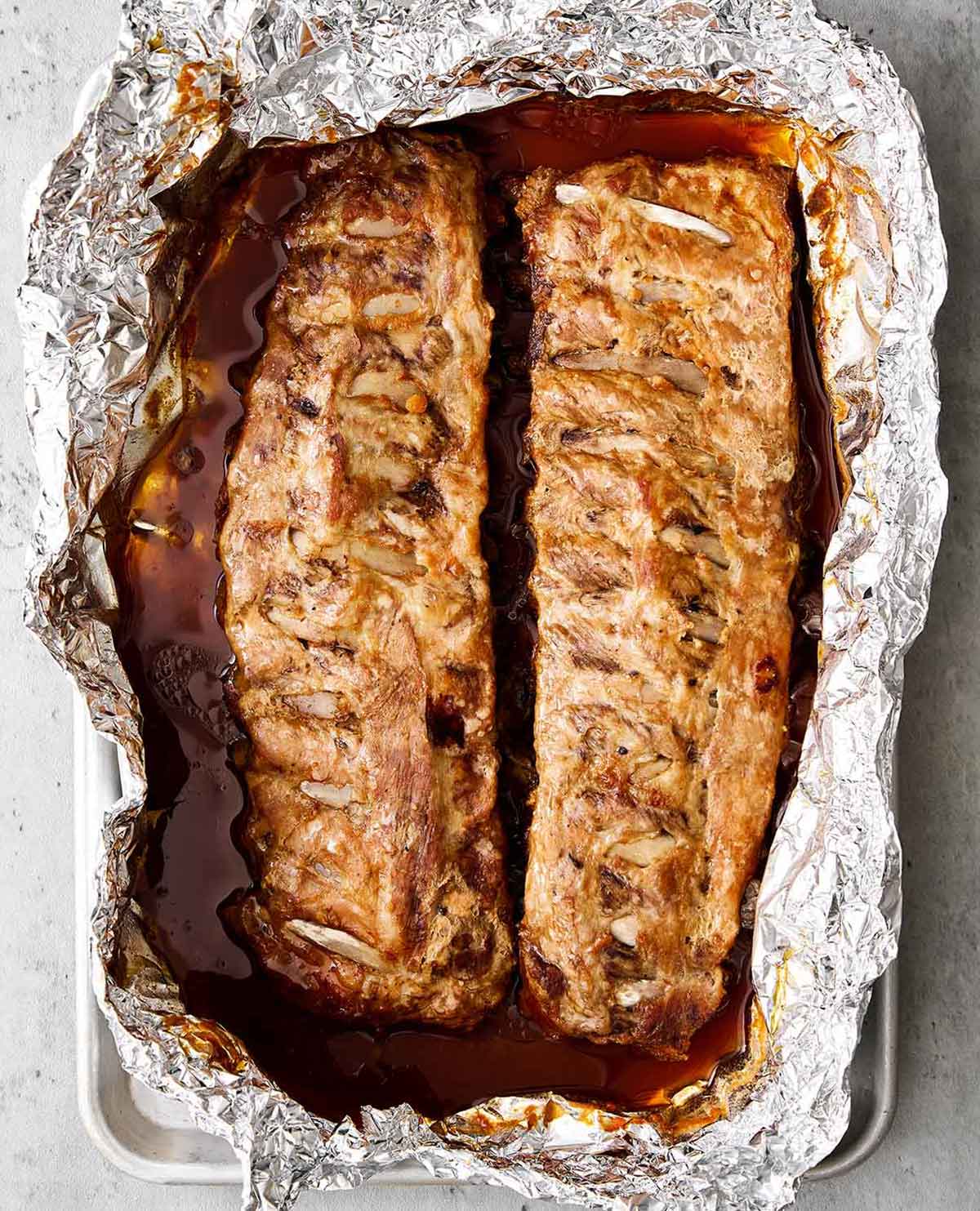 These baby back ribs are my secret to the best cookout meal. Guaranteed to be fall-apart tender with the best pineapple BBQ sauce! Oven baked baby back ribs.