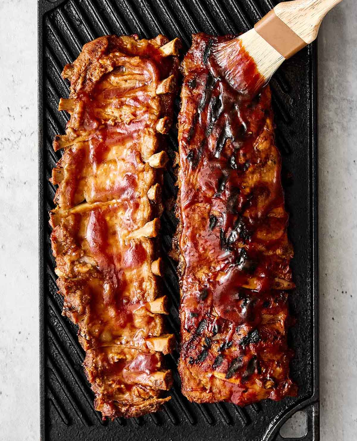 These baby back ribs are my secret to the best cookout meal. Guaranteed to be fall-apart tender with the best pineapple BBQ sauce! Finishing baby back ribs on a grill.