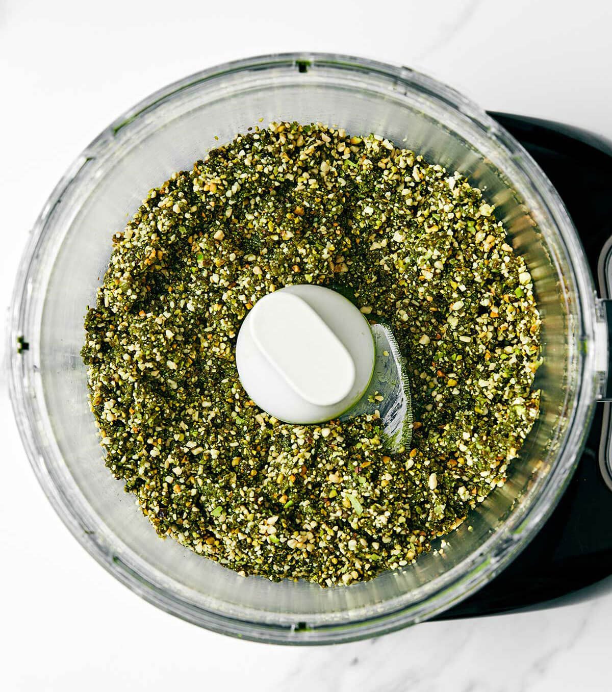 These matcha energy balls are my favorite power-packed healthy snack with matcha (green tea), cashews, dates, pistachios, and shredded coconut. Plus, they’re super easy to make and prep for the week! Matcha balls in food processor.