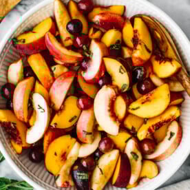 A large white bowl of stone fruit salad