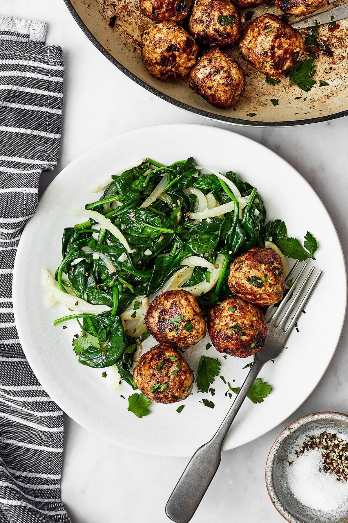 Pork meatballs with sauteed spinach on a plate