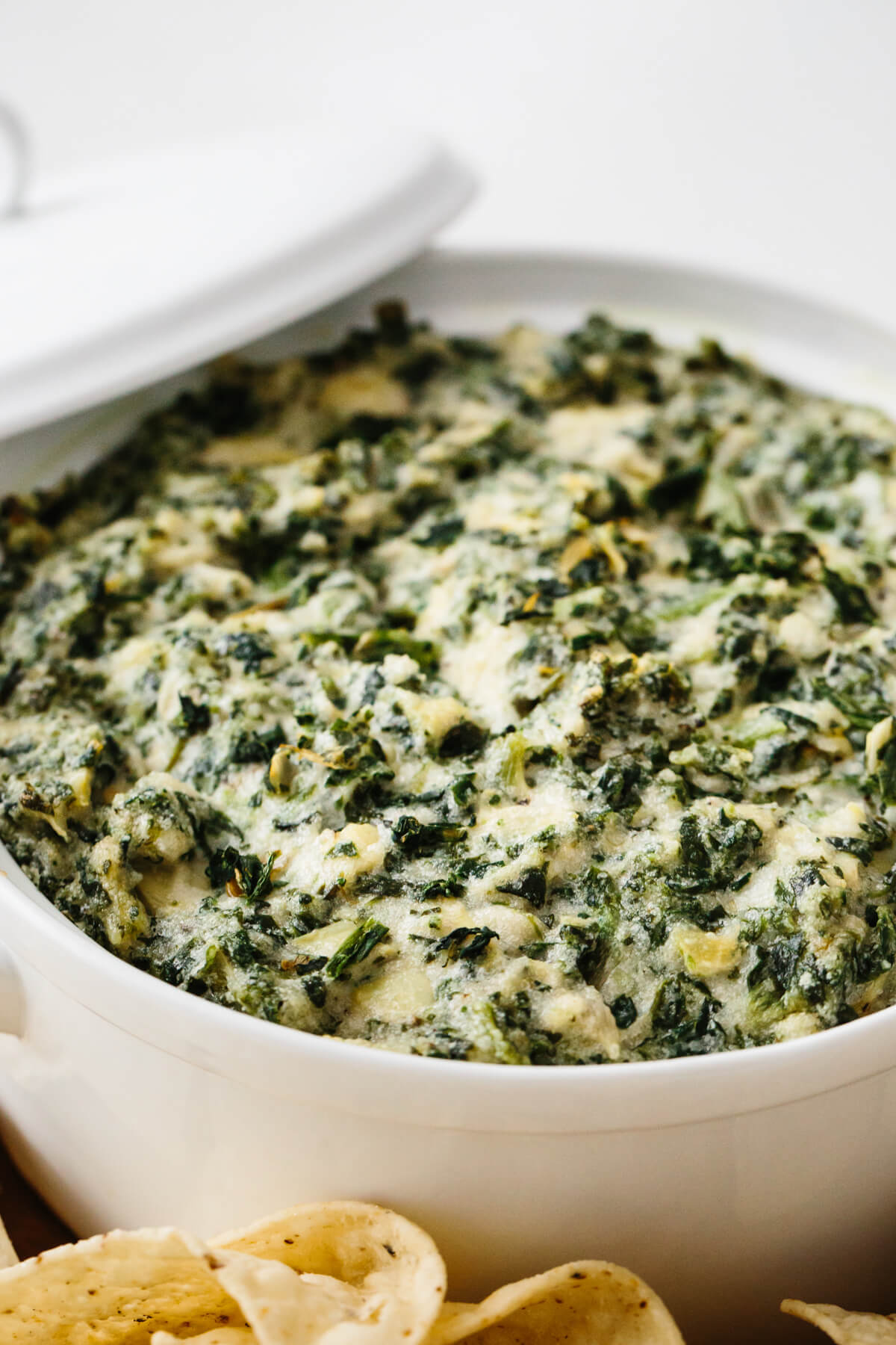Spinach artichoke dip in a white casserole dish.