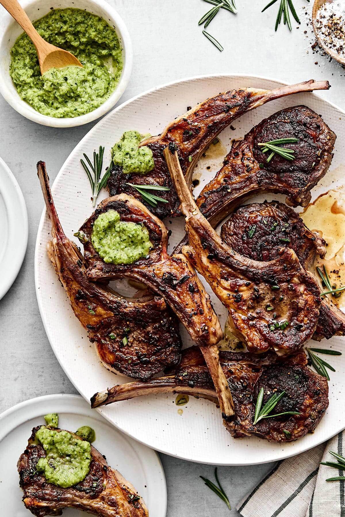 A plat of grilled lamb chops with a fresh mint apple sauce.