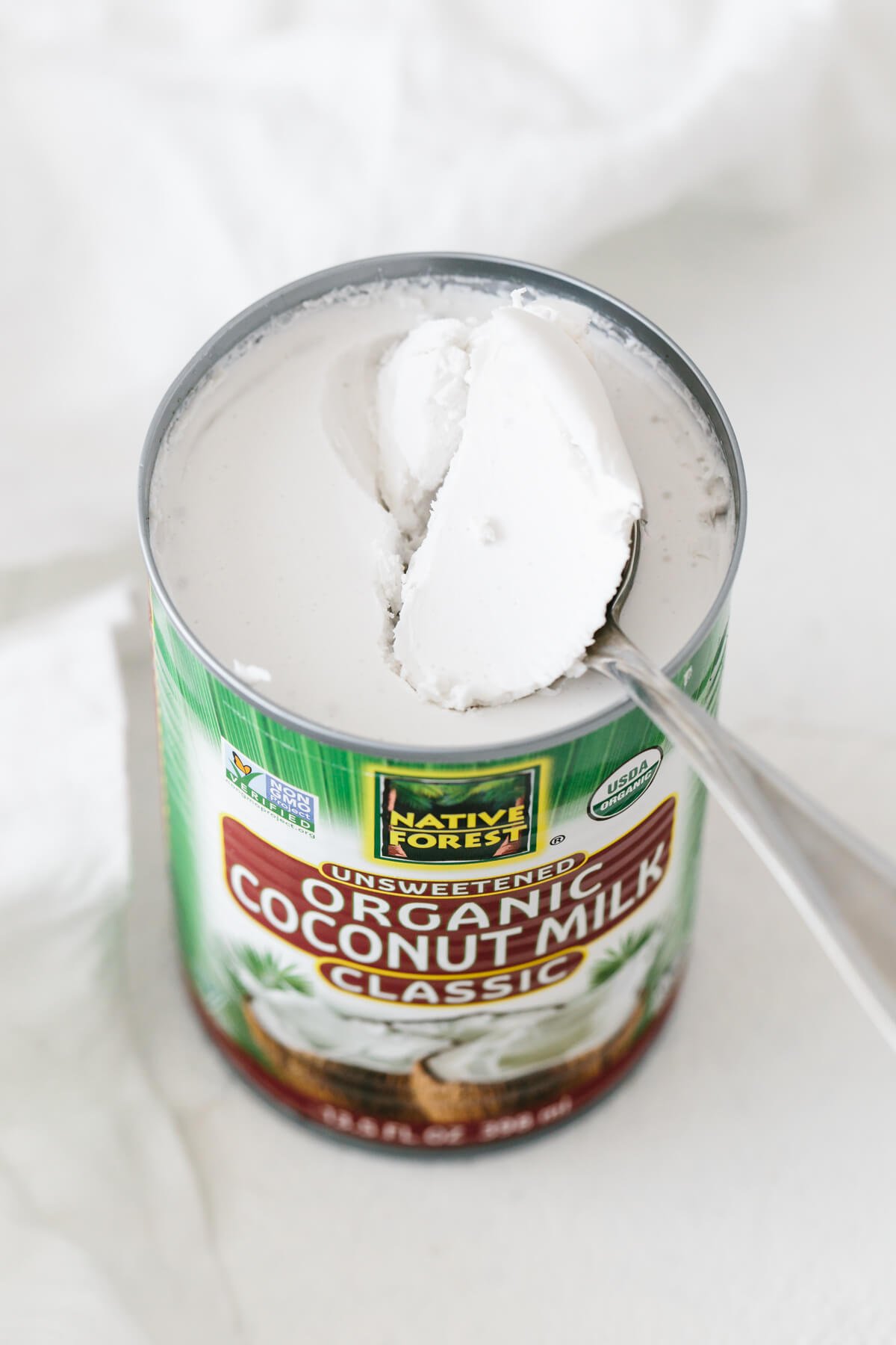 An open can of coconut milk, with hardened coconut cream at the top.