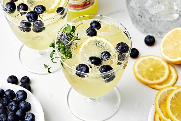 Blueberries and thyme in a glass of limoncello prosecco.