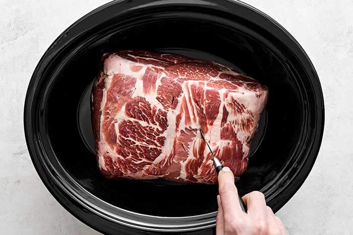 Prepping Kalua pork in slow cooker.