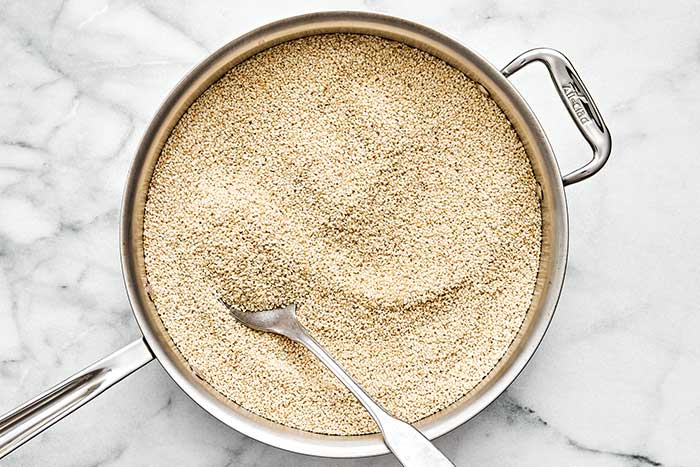 Toasting sesame seeds in a pan.