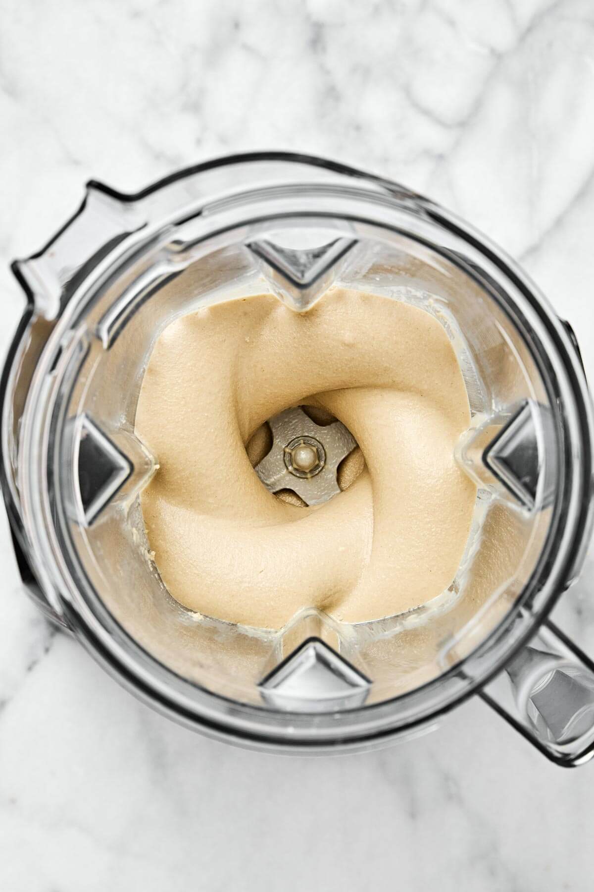 It’s super easy to make homemade tahini in a blender! All you need are sesame seeds and olive oil for a fresh, creamy, and smooth texture. Blended tahini.