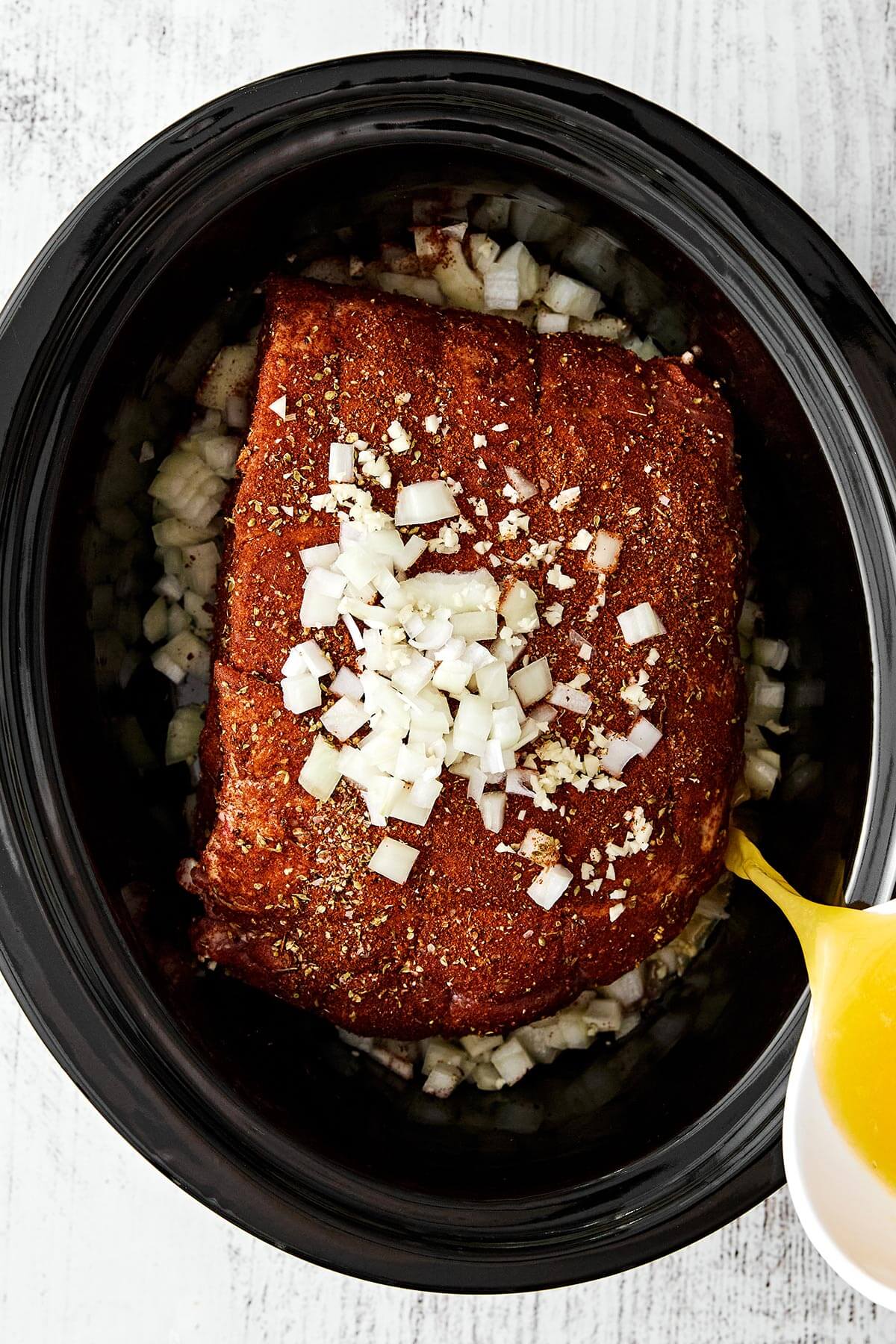 This slow cooker pulled pork is the ultimate “set it and forget” dinner that turns out fall-apart tender and incredibly flavorful every time! Prepping slow cooker pulled pork.