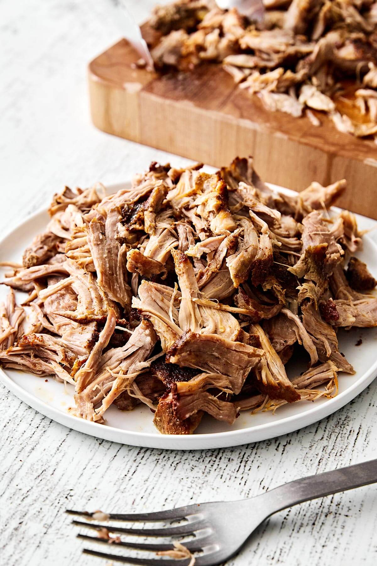 This slow cooker pulled pork is the ultimate “set it and forget” dinner that turns out fall-apart tender and incredibly flavorful every time! Slow cooker pulled pork on a plate.