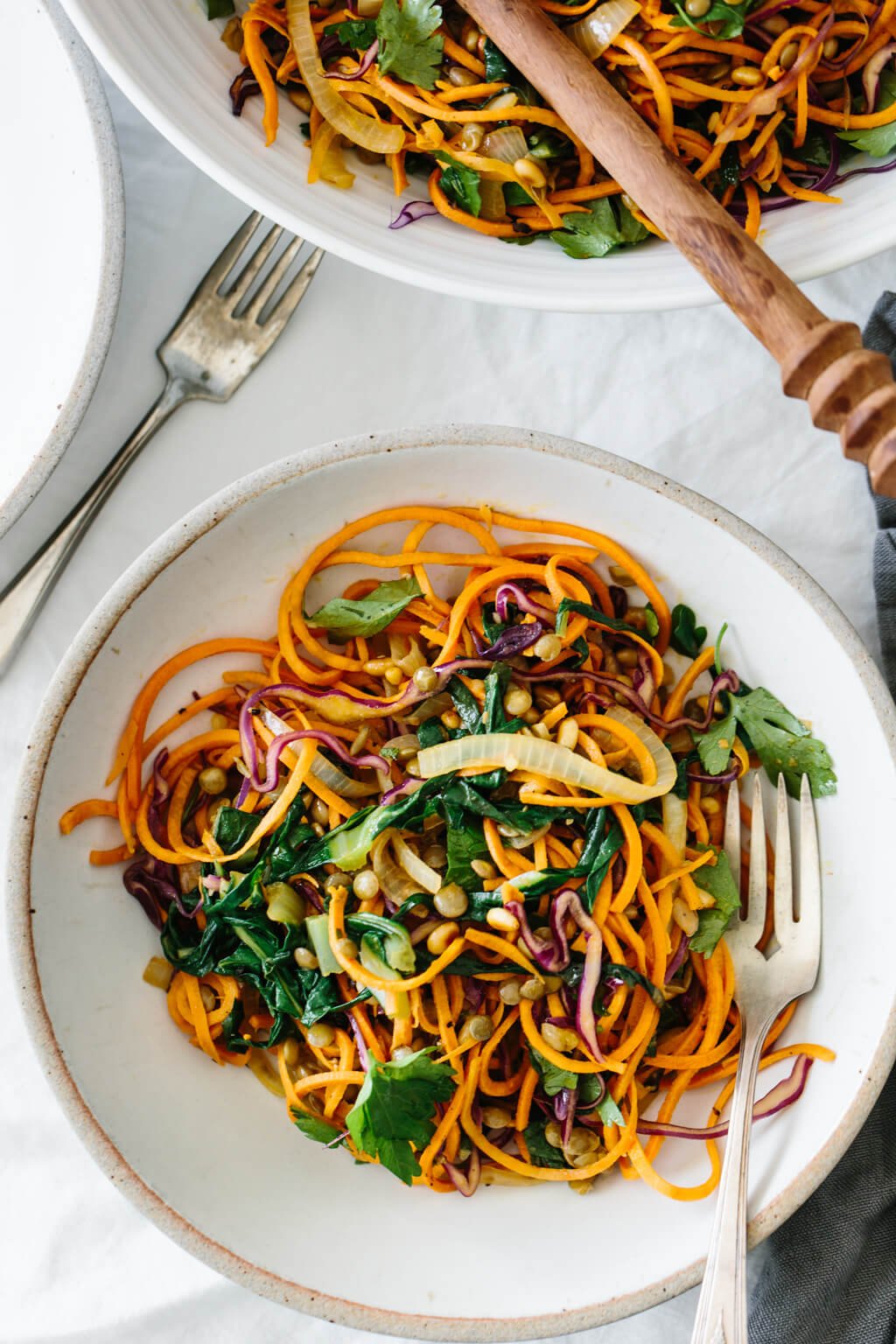 Sweet potato noodles salad is a combination of spiralized sweet potato noodles, cabbage, lentils, sautéed onions and Swiss chard. It's topped off with fresh herbs, toasted pine nuts and a zesty Dijon vinaigrette.