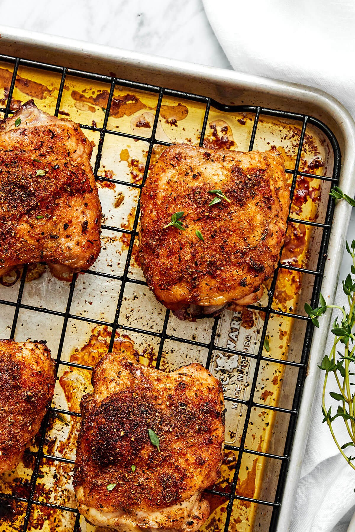 These crispy and juicy baked chicken thighs make for the perfect weeknight meal. They’re incredibly easy to make and packed with flavor! Crispy baked chicken thighs on a baking sheet.