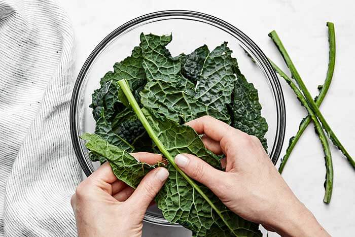Ripping leaves off kale stem.