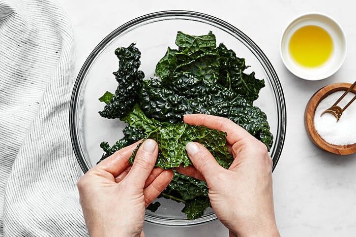 Massaging kale with oil and salt.