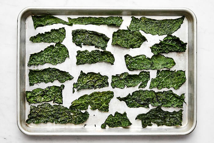 Baked kale chips on a baking sheet.