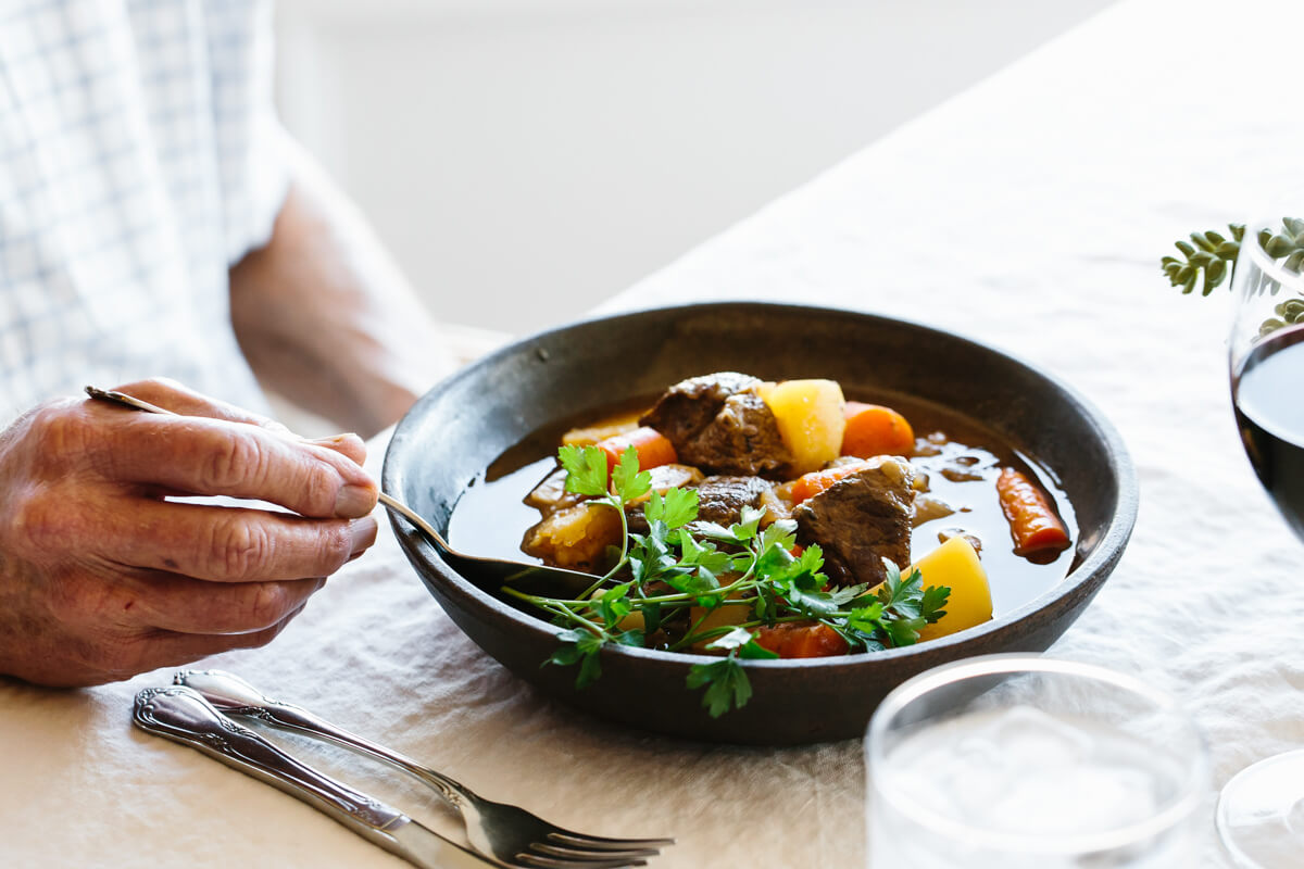 Lamb stew is a warm and flavorful stew recipe of tender lamb, potatoes, turnip, and onions! Eating lamb stew in a bowl.