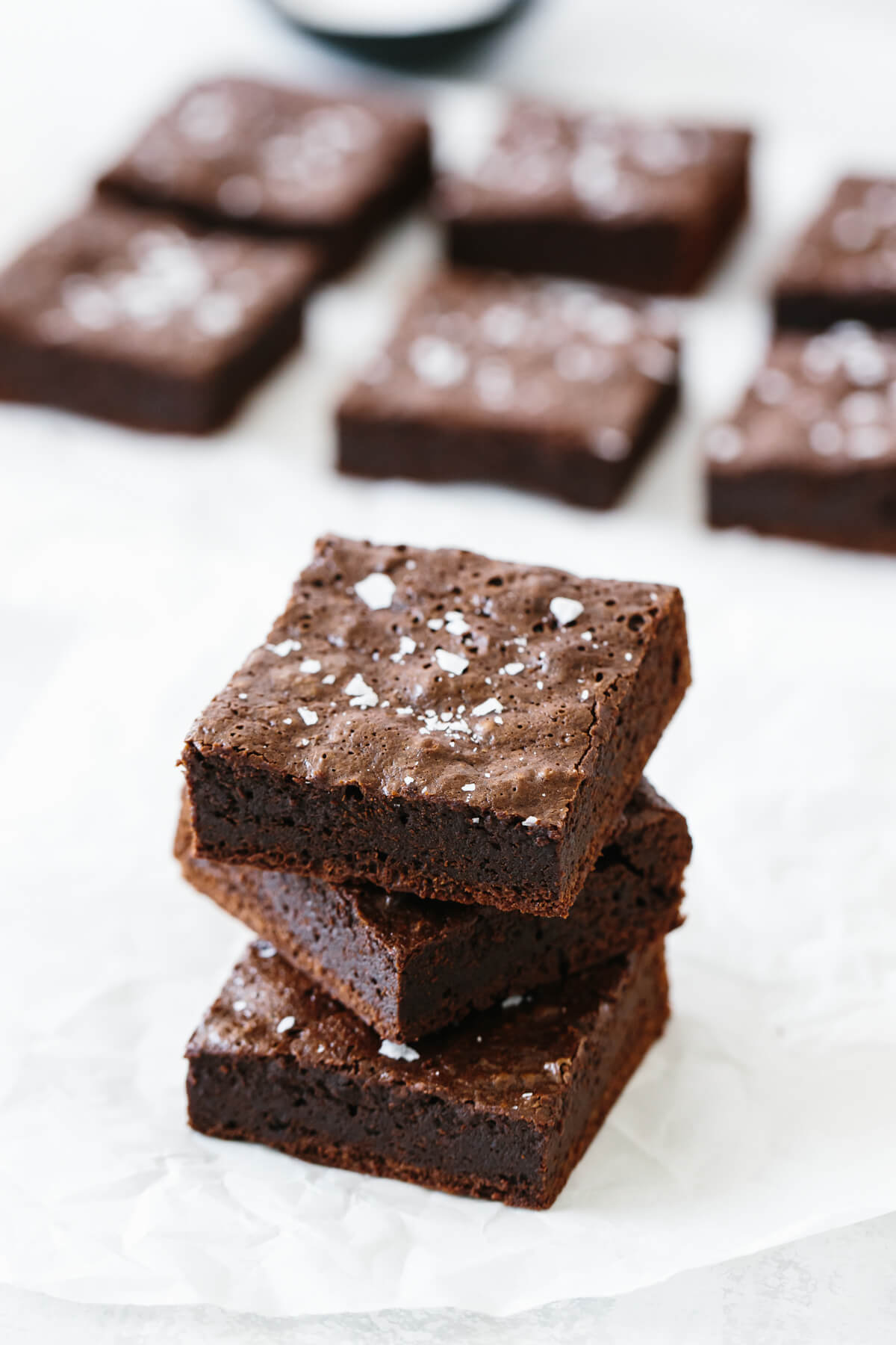 Paleo brownies are rich, chocolatey and fudgy brownies that are an easy dessert recipe. You'll never know that they're gluten-free and dairy-free because they're so decadent and delicious. Several paleo brownies on a table.