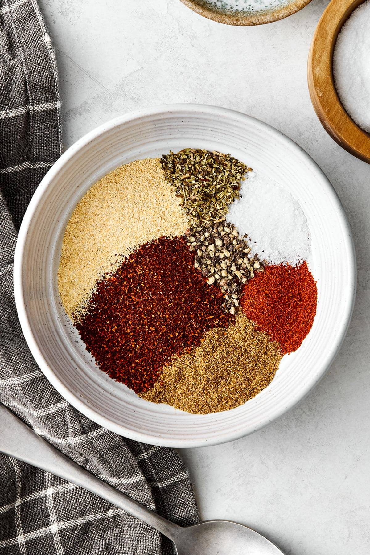 This taco seasoning will beat the store-bought version any day! It's super easy, inexpensive, and doesn't container filler ingredients. Taco seasoning ingredients in a bowl.
