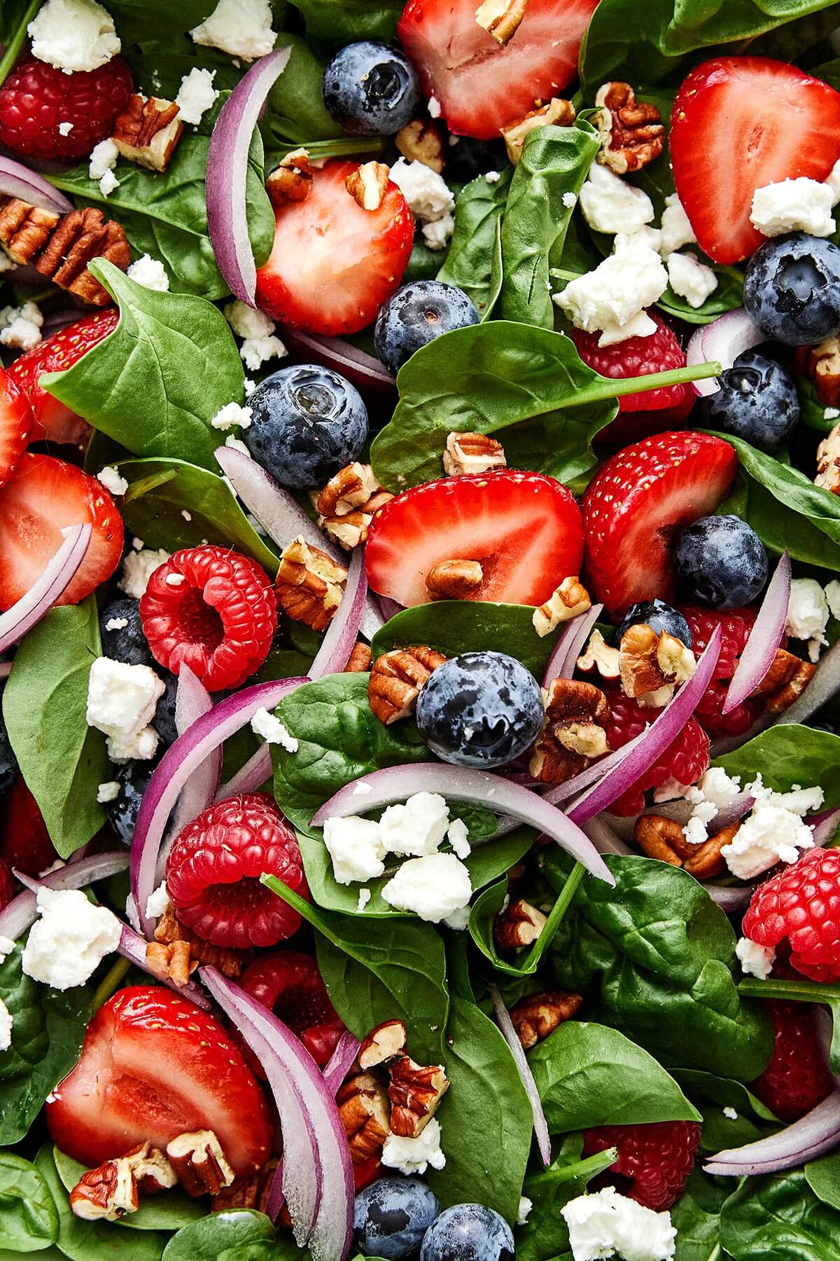 Spinach salad with strawberries, blueberries, and raspberries.