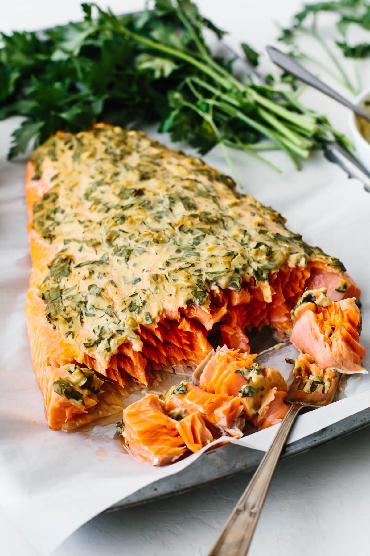 A piece of dijon baked salmon next to parsley.