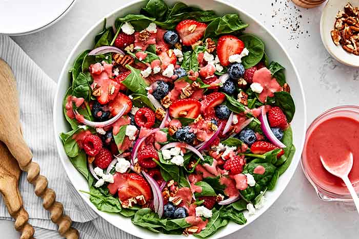 A bowl of berry spinach salad.