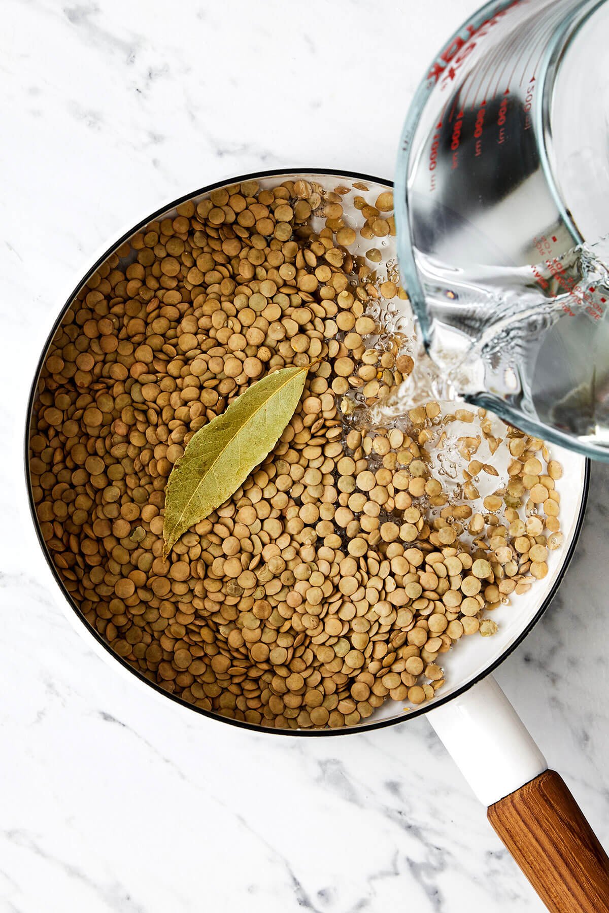 This lentil salad is crisp, fresh, and light with diced cucumber, red onion, dates, fresh herbs, and a bright lemon vinaigrette. Boiling lentils in a pot.