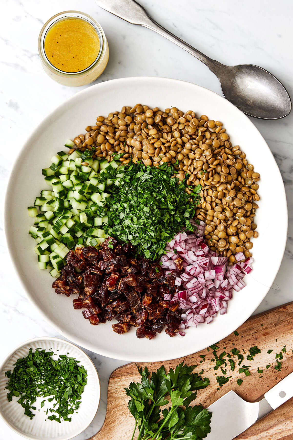 This lentil salad is crisp, fresh, and light with diced cucumber, red onion, dates, fresh herbs, and a bright lemon vinaigrette. Lentil salad ingredients in a bowl.