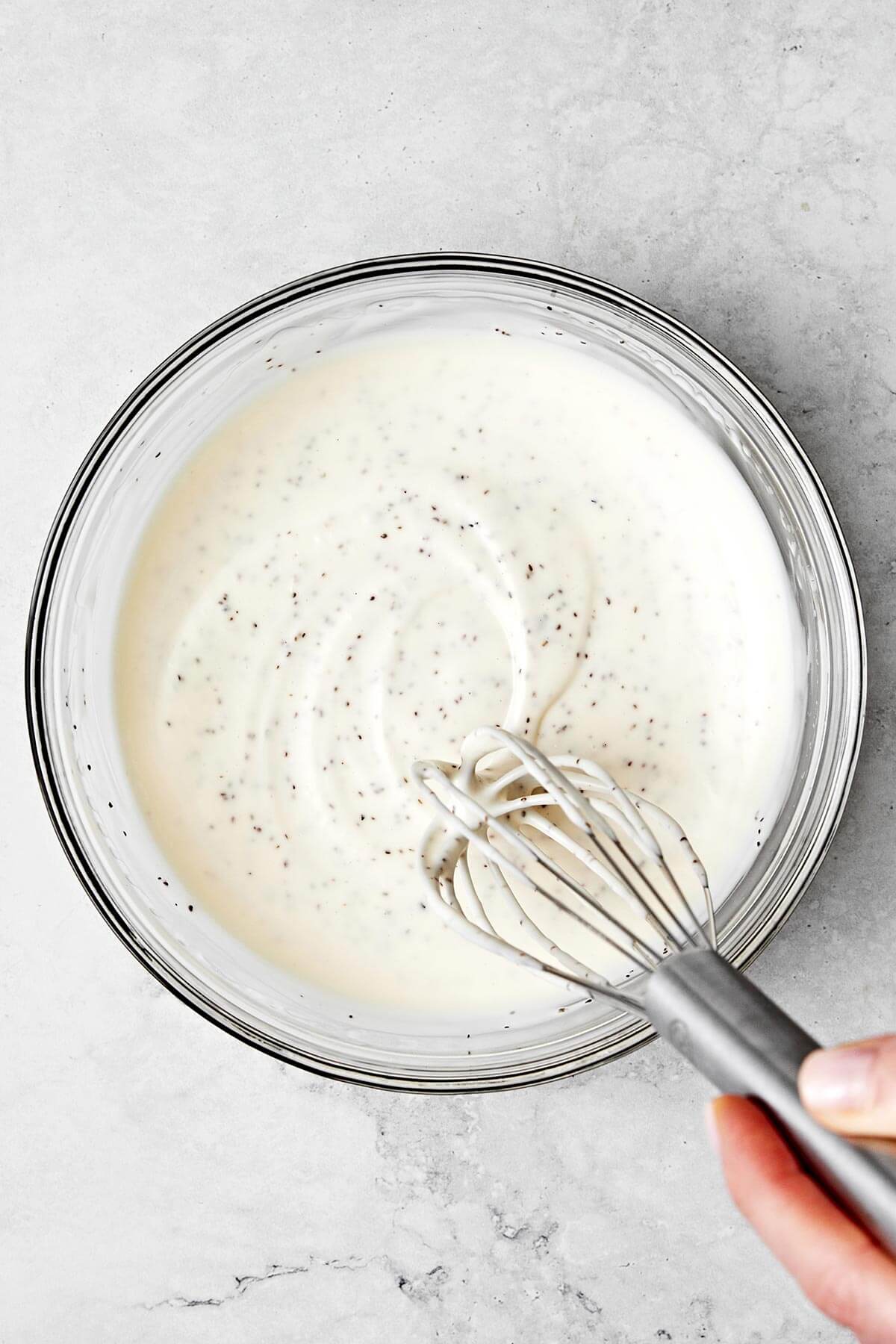 A homemade coleslaw dressing doesn’t get any better than this — tangy, slightly sweet, and perfectly creamy. Mixing coleslaw dressing in a bowl.