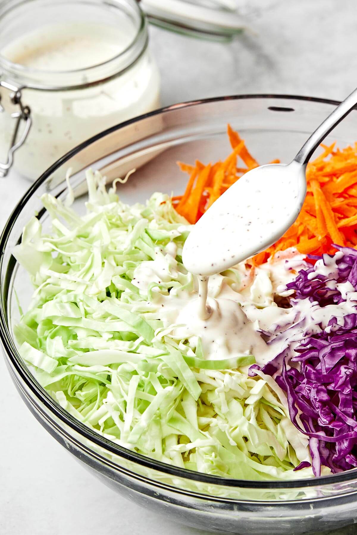 A homemade coleslaw dressing doesn’t get any better than this — tangy, slightly sweet, and perfectly creamy. Pouring coleslaw dressing.