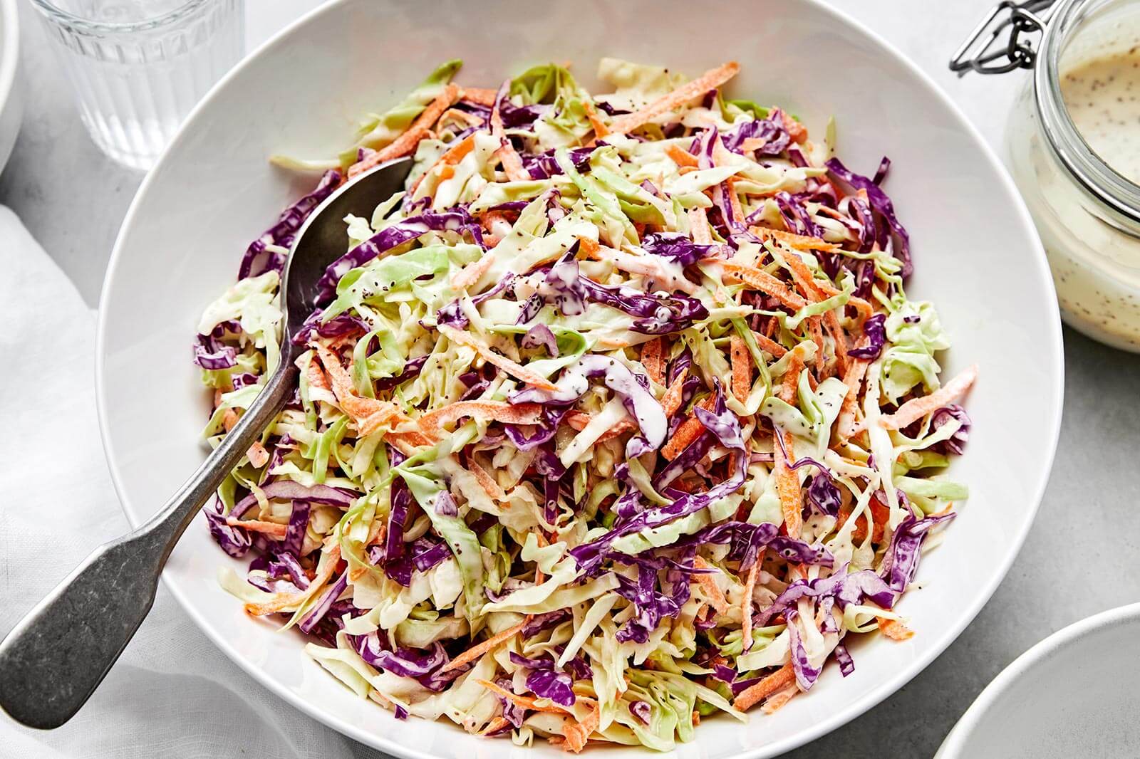 A white bowl of creamy coleslaw.
