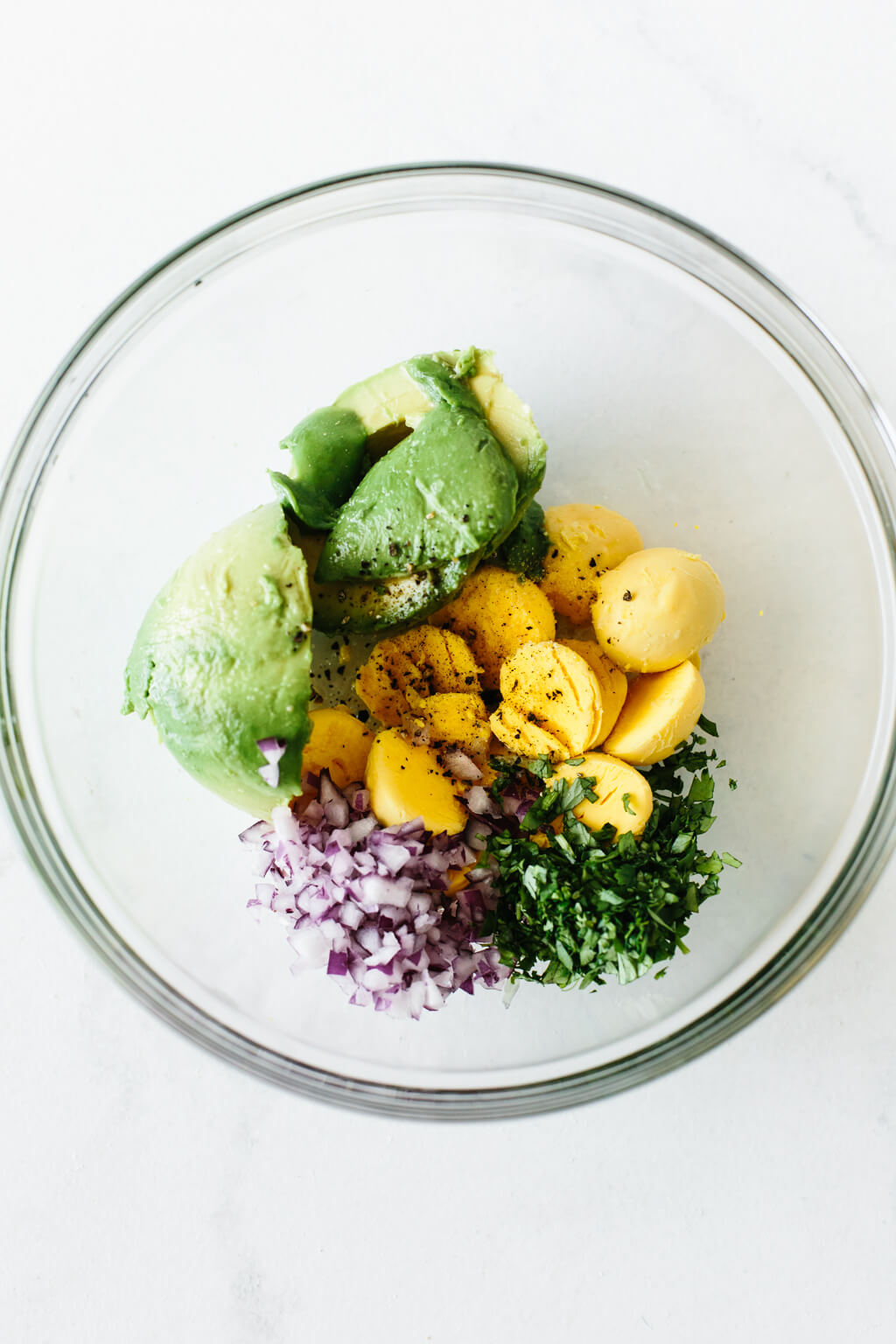 Avocado deviled eggs ingredients in a mixing bowl.