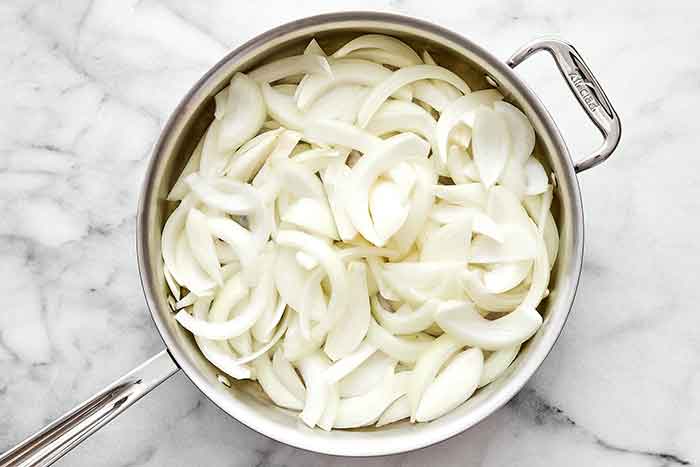 Step one of caramelized onions: add onions to pan.