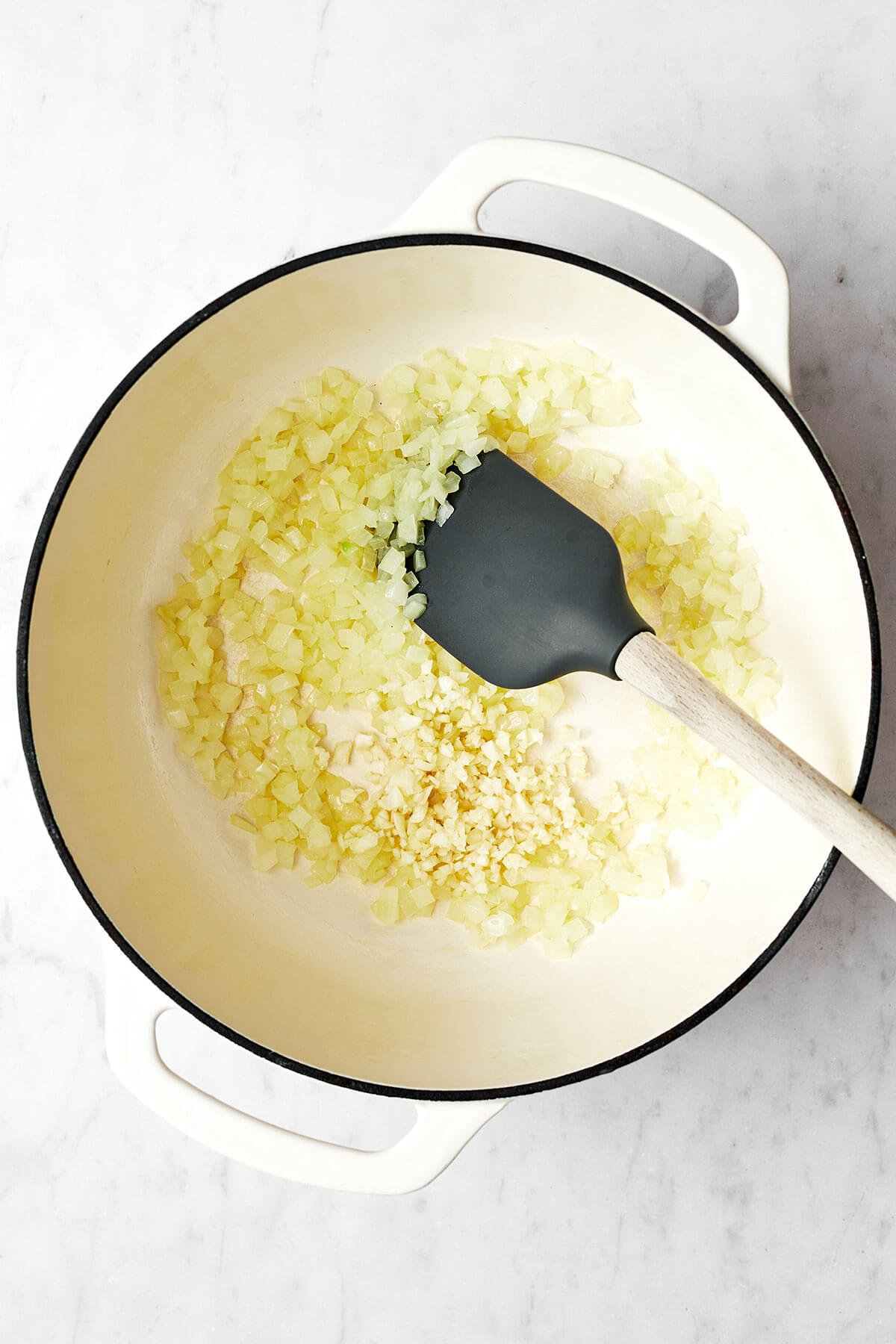 Nothing outshines a fresh batch of this homemade marinara sauce. Bonus — it’s super easy to make with just 5 simple ingredients! Cooking onions in a pot for marinara sauce