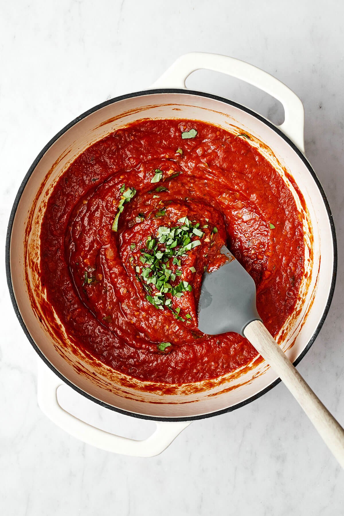 Nothing outshines a fresh batch of this homemade marinara sauce. Bonus — it’s super easy to make with just 5 simple ingredients! Stirring basil into marinara sauce