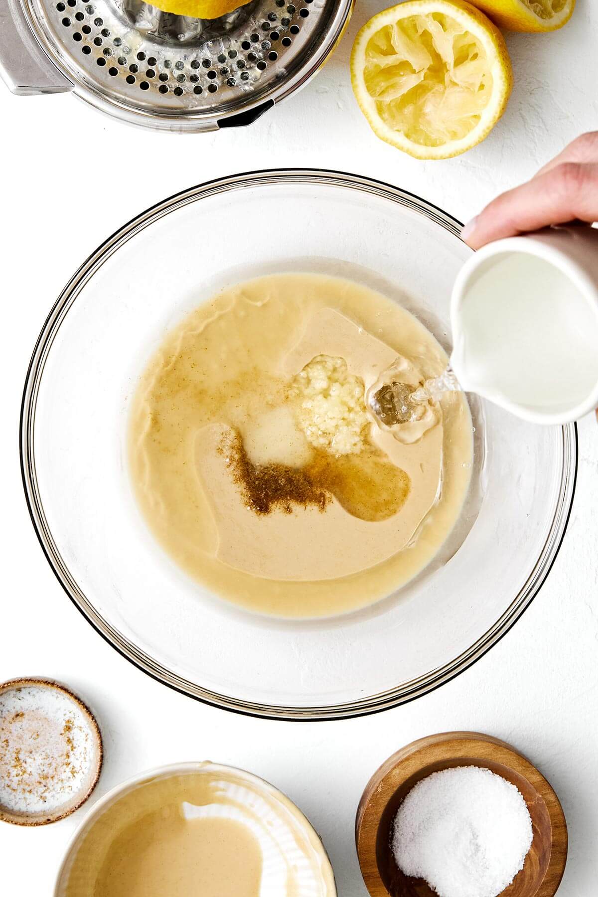 Making tahini sauce in a bowl.