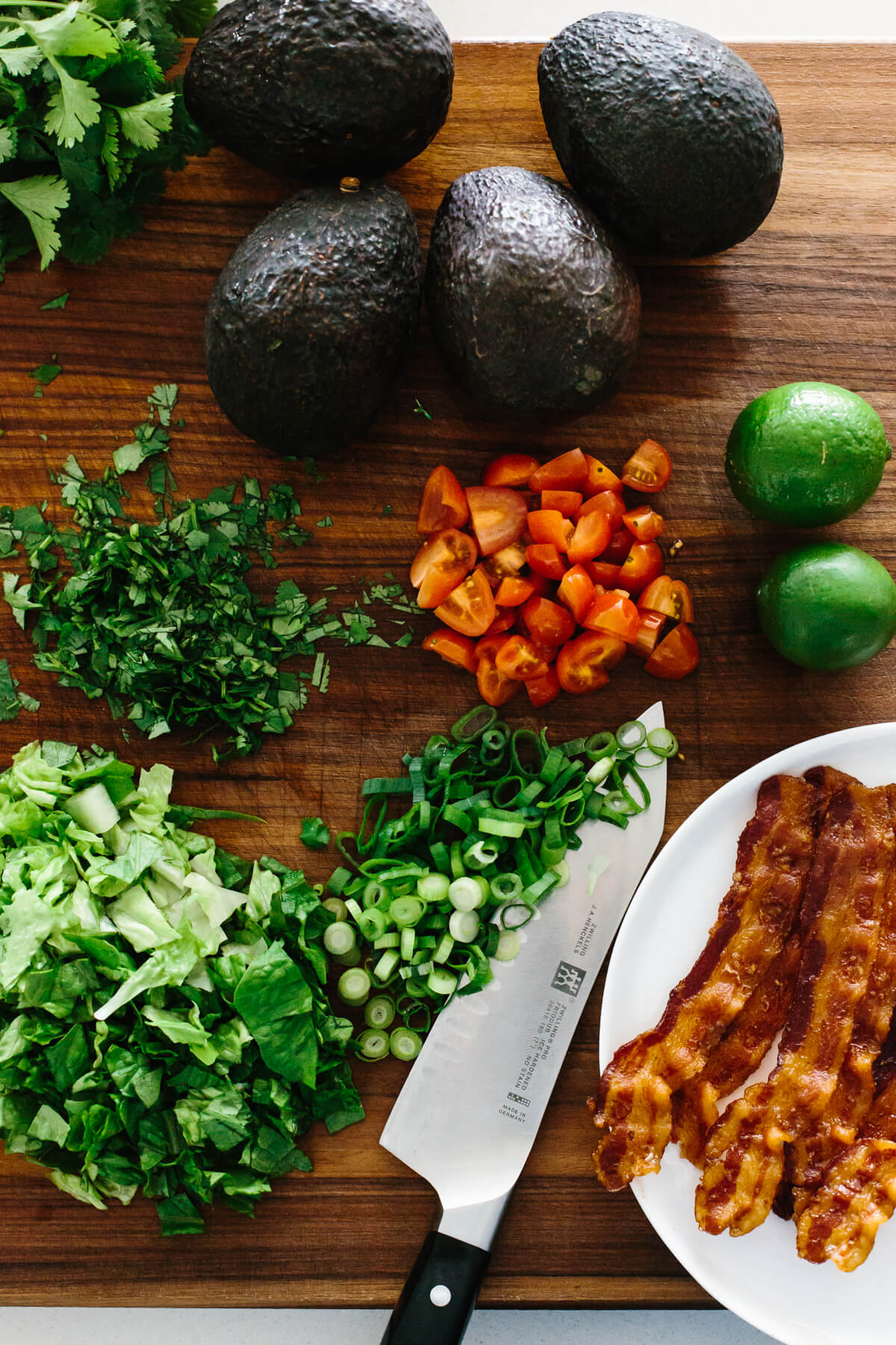 The ingredients for BLT guacamole on a cutting board.