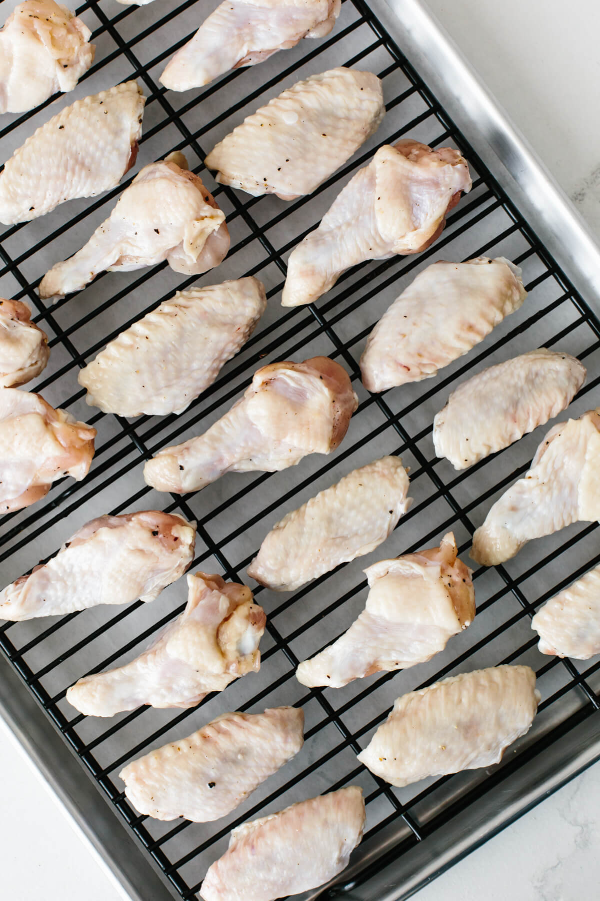 Soy garlic ginger chicken wings are a sticky, sweet and flavorful appetizer with a kick! The perfect party or Super Bowl recipe! Chicken wings on a baking sheet.