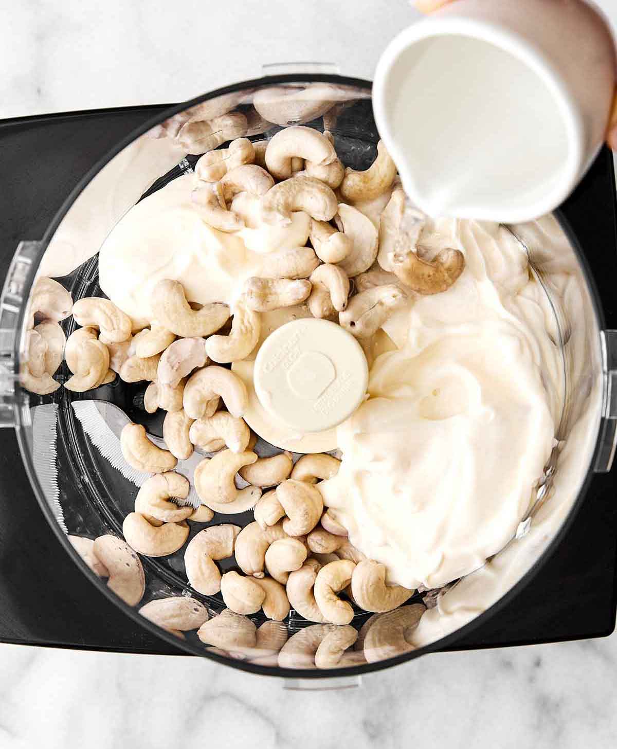 Step one of healthy spinach artichoke dip: blend cashews.