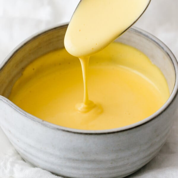 Hollandaise sauce dripping off a spoon.