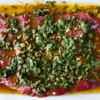 Carne asada marinade on top of steak.