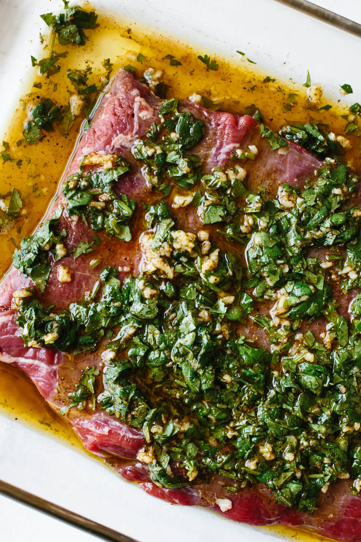 This carne asada marinade is packed with all the essential Mexican flavors! Carne asada marinade on top of flank steak.