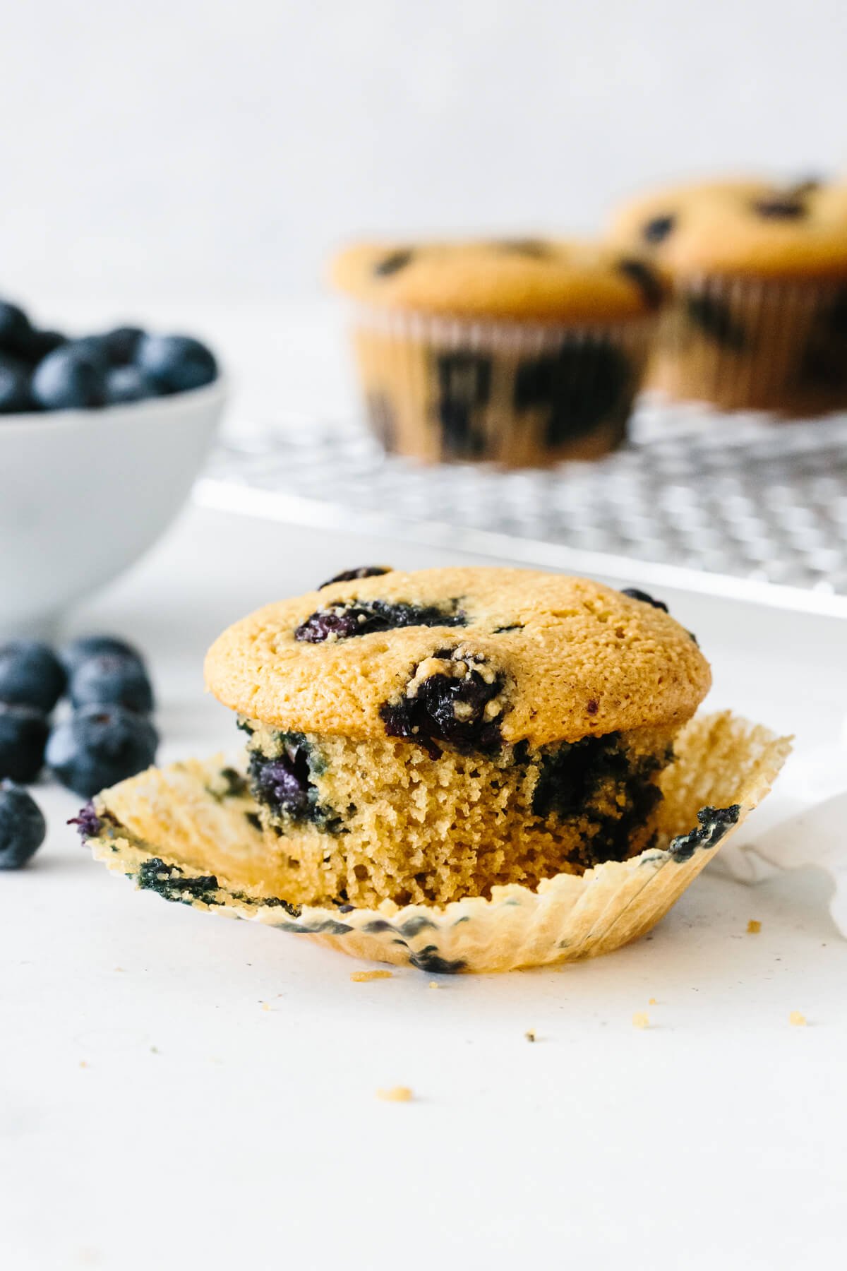 Paleo blueberry muffins are sweet, moist and fluffy! They're also gluten-free and dairy-free. One paleo blueberry muffin with wrapper peeled.