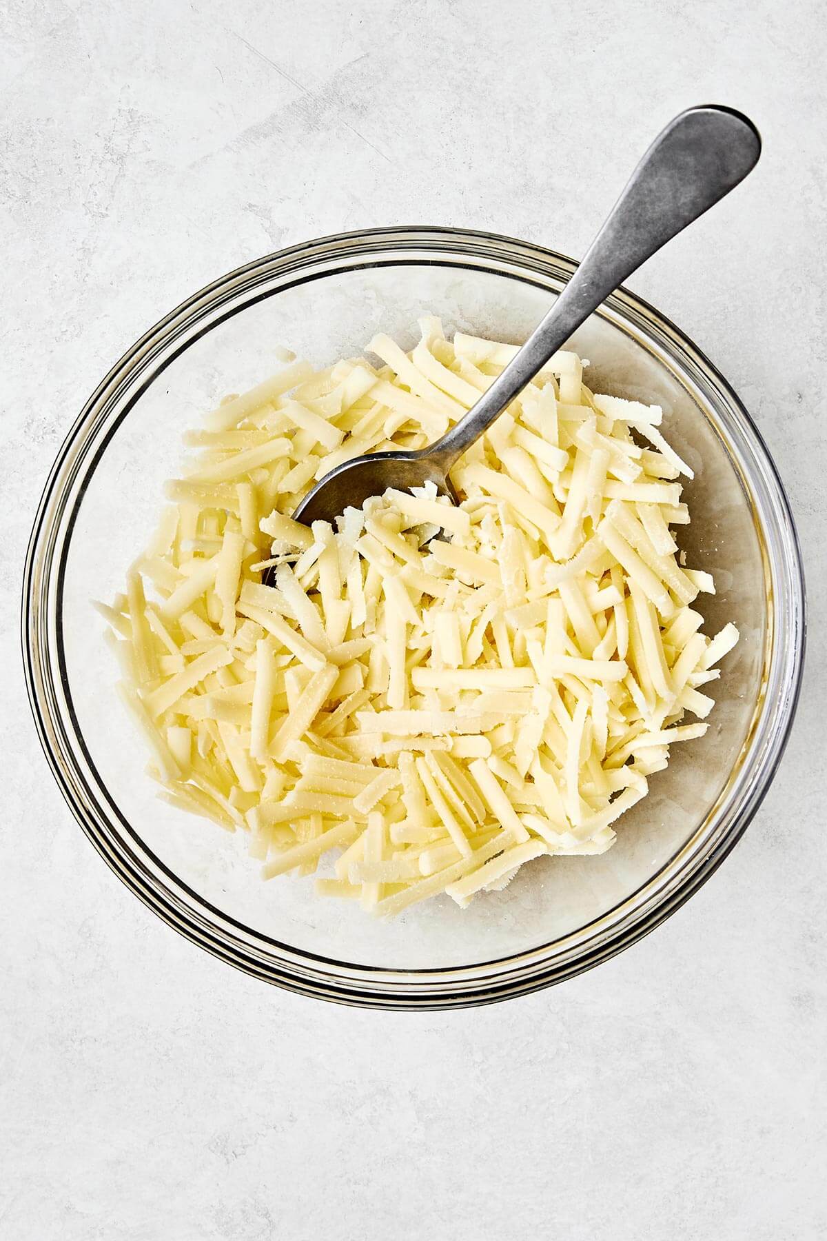 This scalloped potatoes recipe will have everyone going back for seconds! It's creamy, cheesy, and an easy side dish to make. Mixing cheese blend in a bowl.