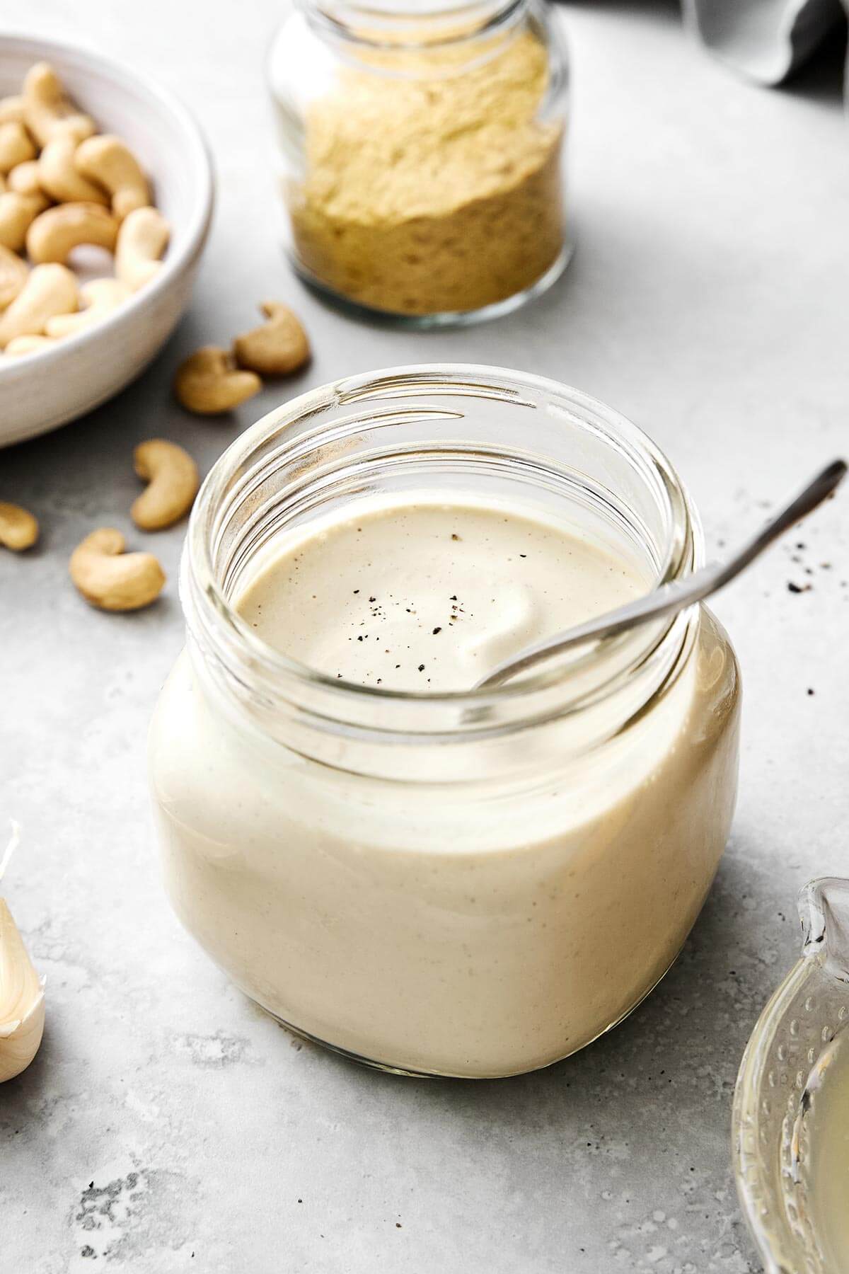 A glass jar of vegan alfredo sauce.