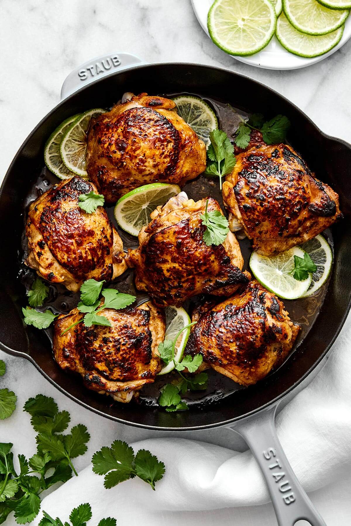 This cilantro lime chicken is incredibly juicy, bursting with bright flavors, and an easy weeknight dinner everyone will love. A skillet of cilantro lime chicken thighs.