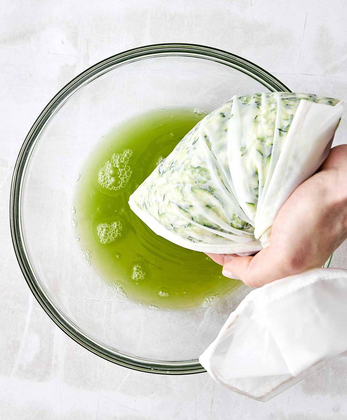 Zucchini fritters are everyone’s favorite summer dinner. With savory flavors, crispy edges, and a dollop of creamy garlic chive yogurt sauce, it's the perfect zucchini recipe to keep in rotation! Draining liquid out of grated zucchini.