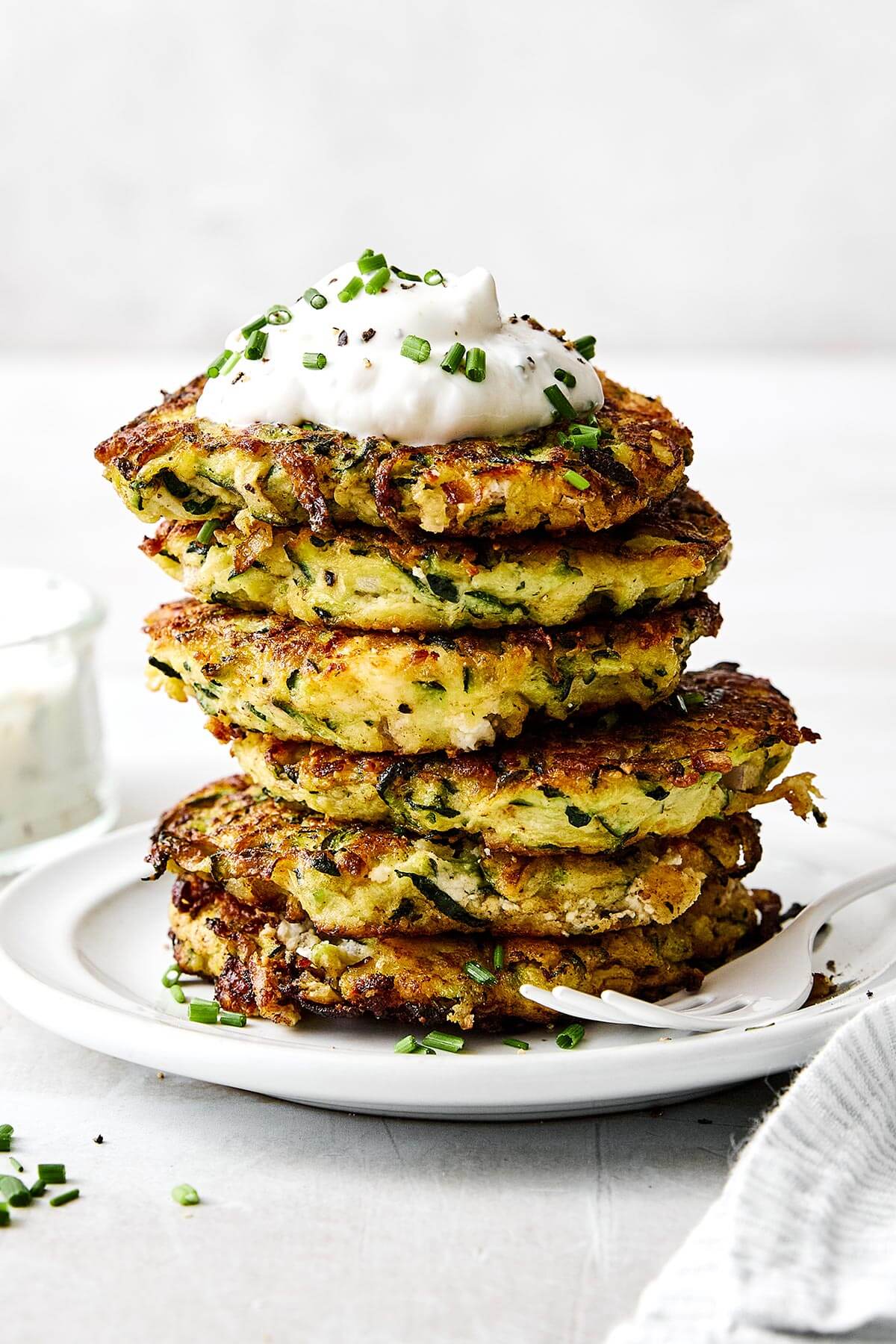Zucchini fritters are everyone’s favorite summer dinner. With savory flavors, crispy edges, and a dollop of creamy garlic chive yogurt sauce, it's the perfect zucchini recipe to keep in rotation!