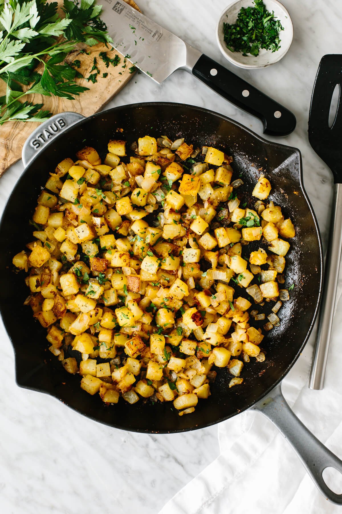 Breakfast potatoes in a skillet on a table.