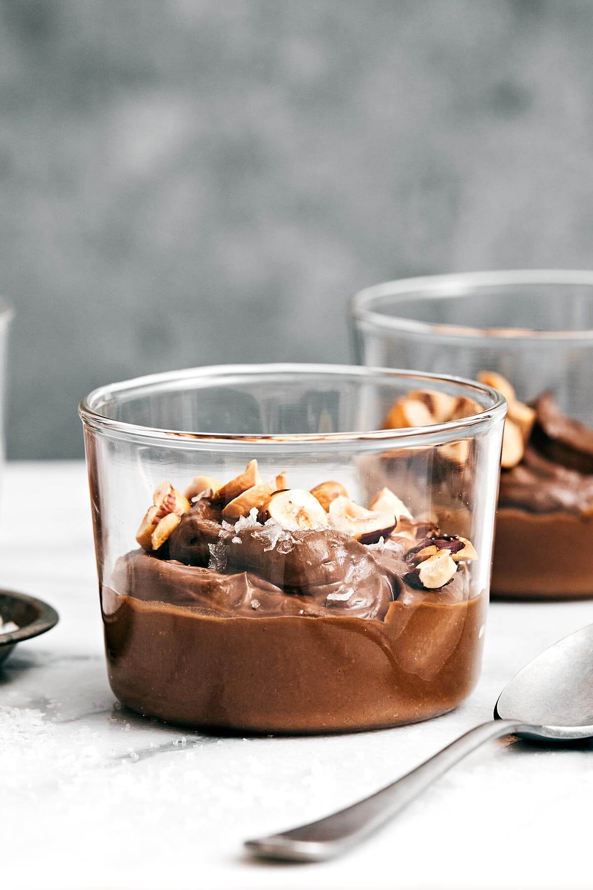 This easy chocolate avocado pudding recipe is one of my all-time favorite healthy desserts! Plus, it's vegan and dairy-free. Chocolate avocado pudding in a glass cup.